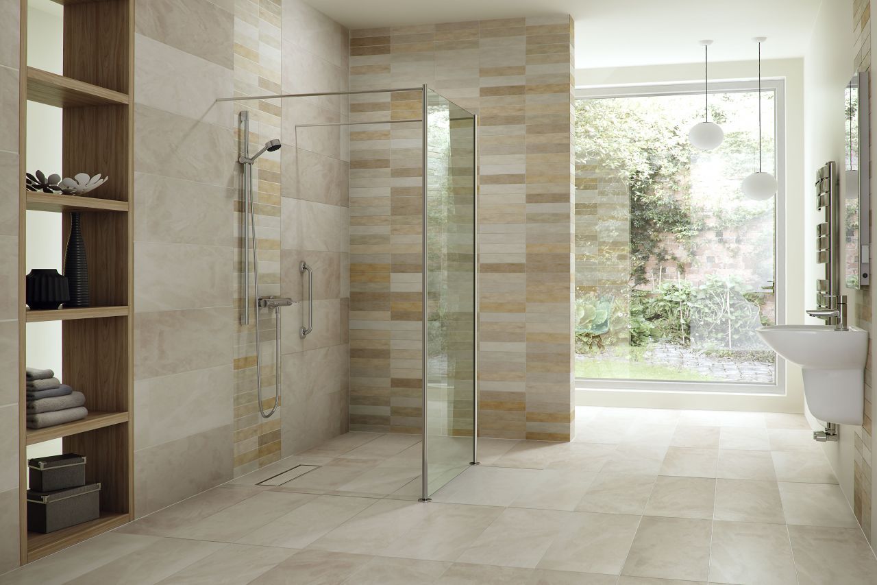 Zero-threshold accessible shower with flush tile entry, chrome grab bars, handheld shower fixture, and glass shower screen