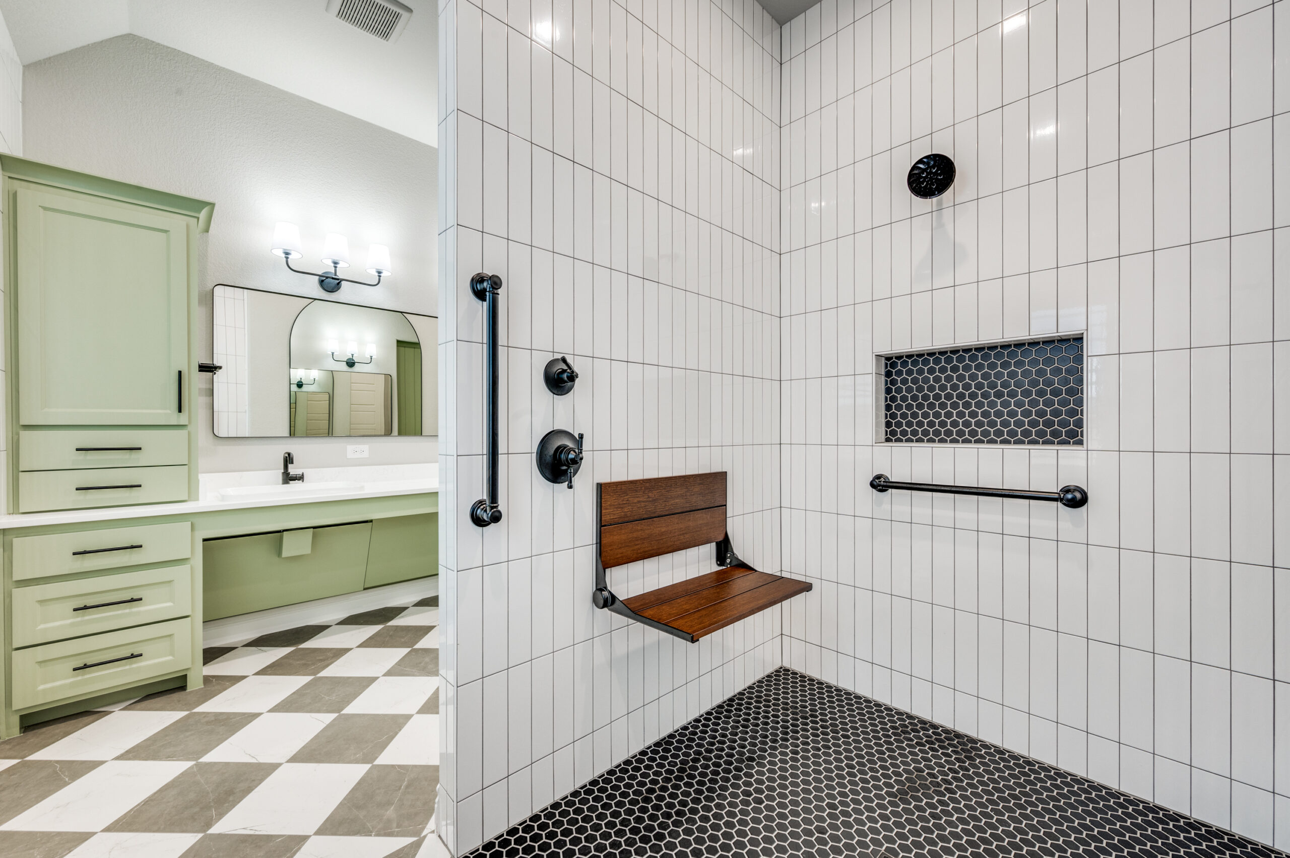 Aging-in-place bathroom with curbless shower, bench, grab bars, handheld shower, non-slip flooring, and roll-under vanity