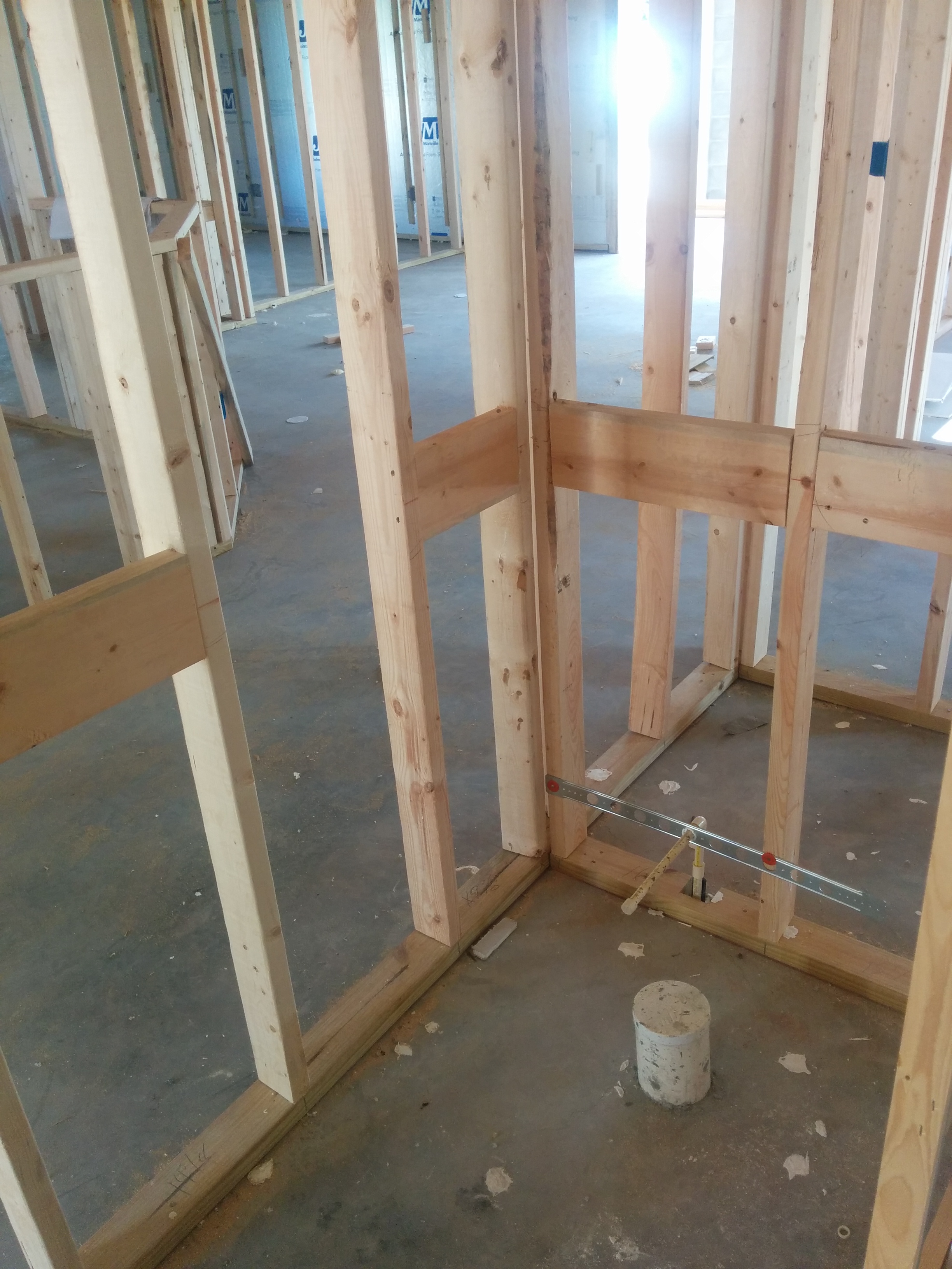 Open bathroom wall with wood blocking installed between studs for future grab bars