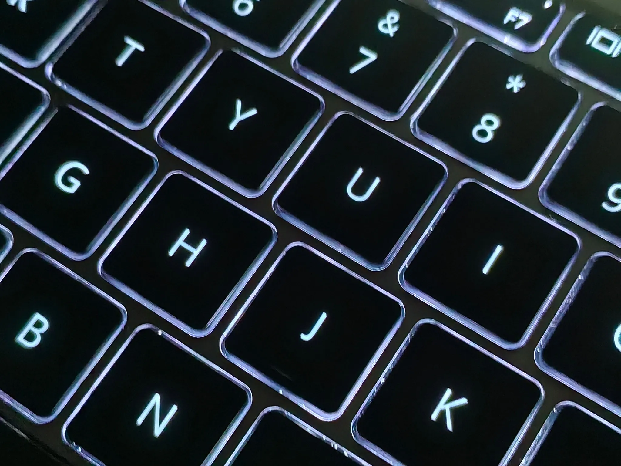 Close-up of a backlit laptop keyboard with evenly spaced keys