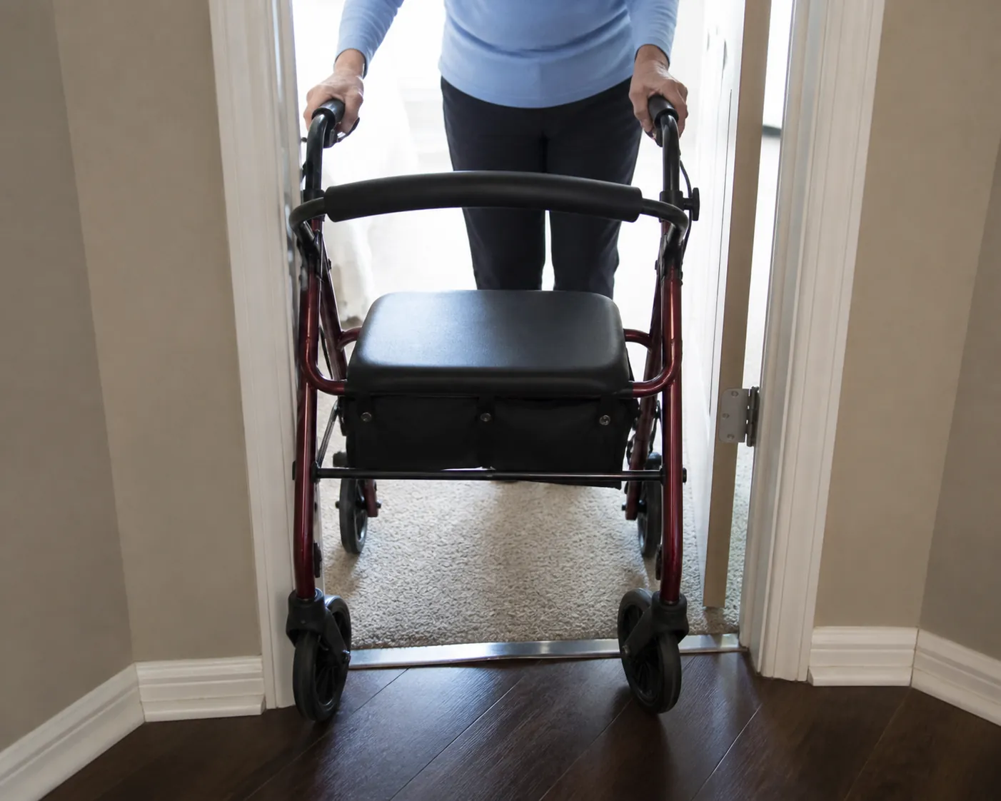Rollator walker being guided through a doorway with tight clearance on both sides