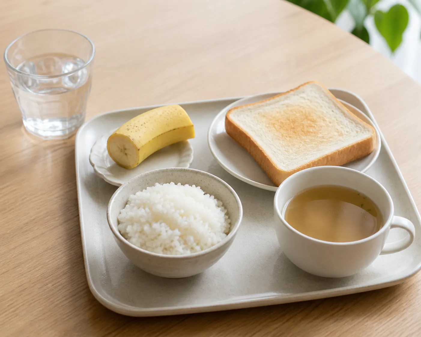 Small recovery meal of rice, toast, banana, broth, and water