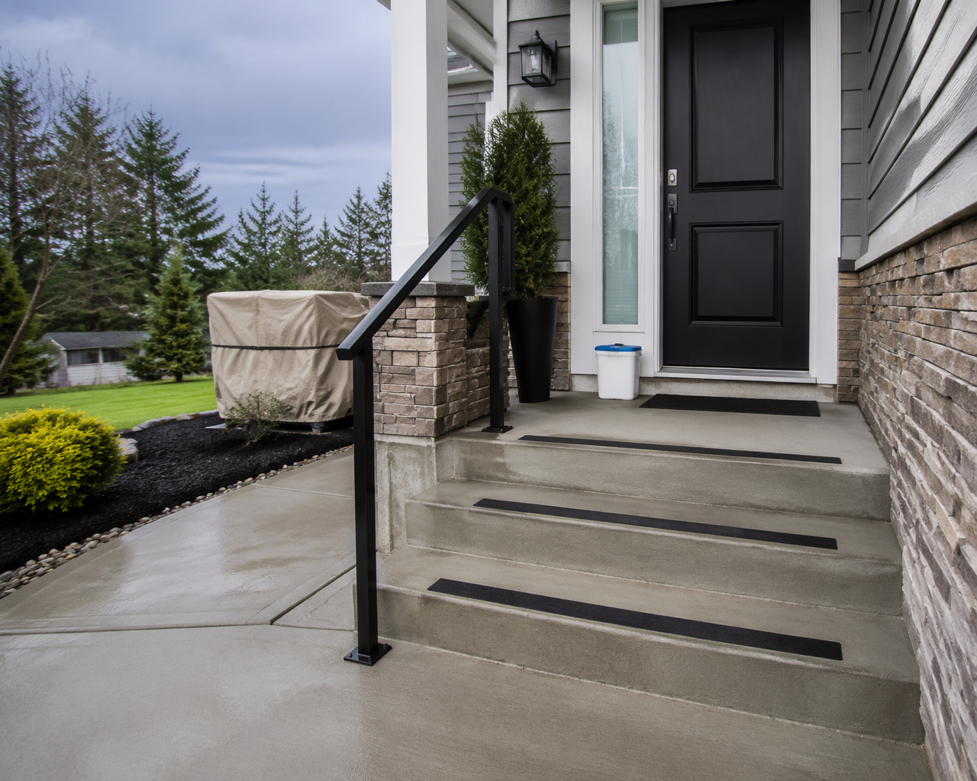 Home entryway steps with non-slip traction strips, a handrail, clear walkway, and ice melt near the door
