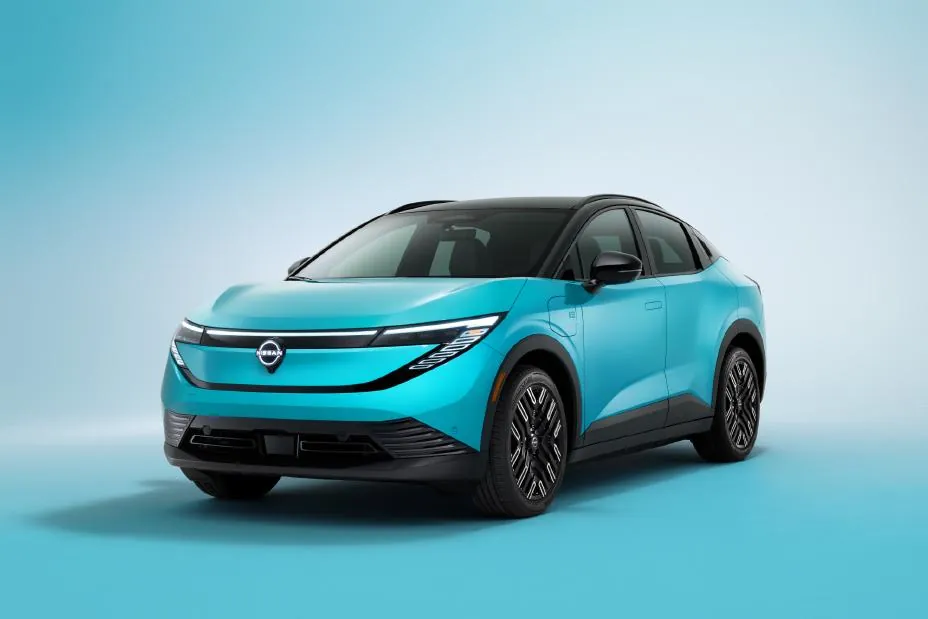 Red 2026 Nissan Leaf driving on a road with redesigned crossover shape