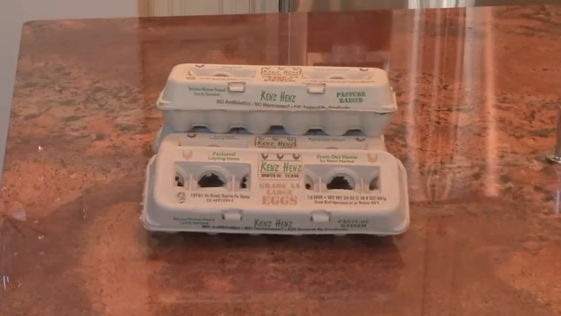 Kenz Henz egg carton with brown eggs on a kitchen counter