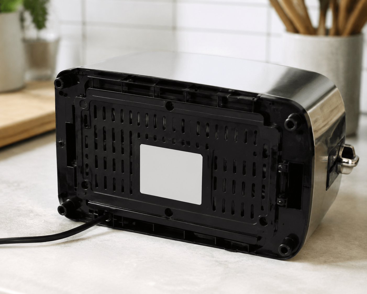A toaster tilted on a counter to show a rating label with model and serial information
