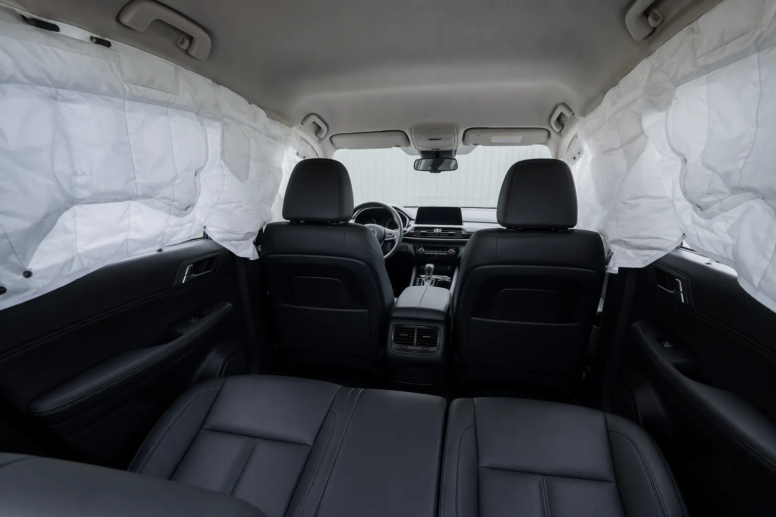 Side curtain airbags deployed along both side windows inside a modern car